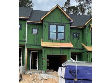 Unfinished townhome showcasing windows, garage, and Zip System sheathing, awaiting its final touches at 4073 Elk Creek Ln, Raleigh, NC 27612