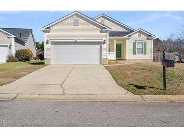 Charming home featuring a two-car garage, green shutters, and a well-manicured lawn at 4913 Sugargrove Ct, Apex, NC 27539
