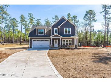 Charming two-story home with gray siding, a well-manicured yard and a two car garage at 6935 Old Jefferson Hwy, Cameron, NC 28326