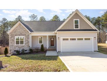 Charming home with a stone facade, a welcoming front porch, and an attached two car garage at 110 Lilac Dr, Franklinton, NC 27525