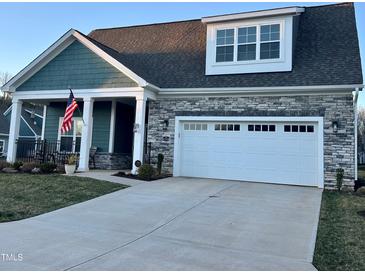 Charming home exterior boasts stone accents, a two-car garage, and a manicured lawn at 1113 Hudson Dr, Mebane, NC 27302