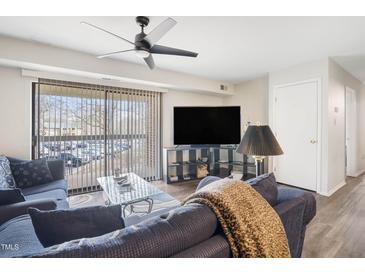 Bright living room featuring a ceiling fan, large sliding glass doors, and comfortable seating at 1287 Schaub Dr # J, Raleigh, NC 27606