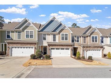 Charming townhomes with attached garages and lovely stone and siding exteriors under a blue sky at 468 Talons Rest Way, Cary, NC 27513