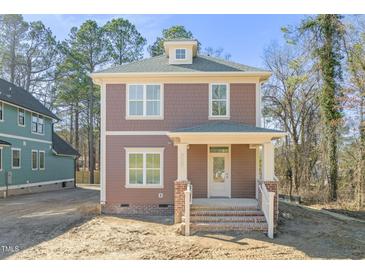 Charming two-story home featuring a welcoming front porch and neutral brown color palette at 717 Heidelberg St, Durham, NC 27704