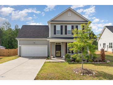 Charming two-story home with a well-maintained lawn, a two-car garage, and lovely landscaping at 155 Jade St, Smithfield, NC 27577