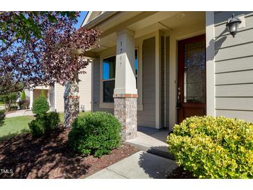 Charming entrance featuring a brick pillar, well-maintained landscaping, and a stylish, paneled front door at 1707 Capstone Dr, Durham, NC 27713