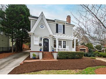 Charming two-story home with landscaped front yard, brick walkway, covered porch and inviting curb appeal at 2147 Wake Dr, Raleigh, NC 27608