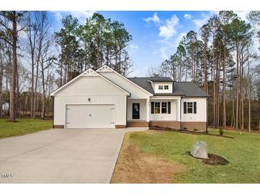 Charming white two-story home with a well-manicured lawn and attached two car garage at 9230 Bear Run Ln, Middlesex, NC 27557