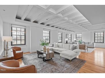 Bright living room featuring hardwood floors, exposed beams, and multiple windows for plenty of natural light at 312 N Buchanan Blvd # 302, Durham, NC 27701