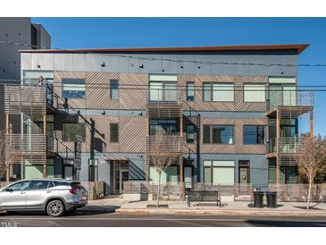 Modern building with a mix of metal and wood exterior, balconies, and a well-maintained surrounding landscape at 521 N Mangum St # 33, Durham, NC 27701