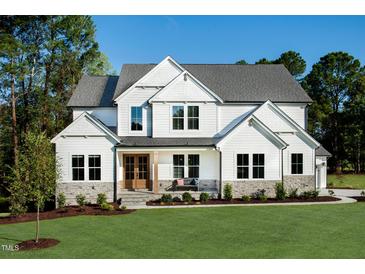 Stunning new two-story white home with beautiful stone accents and professionally landscaped front yard at 83 Stickleback Dr, Willow Springs, NC 27592