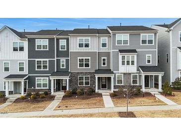 Modern townhomes with gray siding, stone accents, covered entries, and landscaped front yards offer curb appeal at 1430 Rosepine Dr, Cary, NC 27519