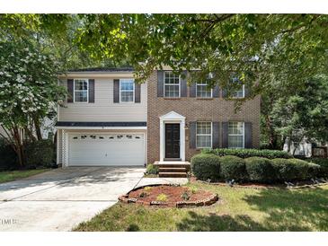 Charming two-story home with brick and vinyl siding, landscaped yard, and a two car garage at 2114 Frissell Ave, Apex, NC 27502
