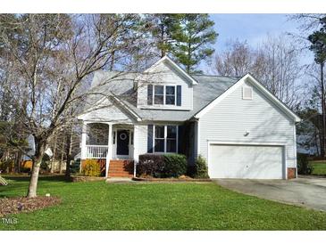 Charming two-story home featuring a covered porch, well-maintained lawn, and attached garage at 2213 Oakhurst Trl, Hillsborough, NC 27278