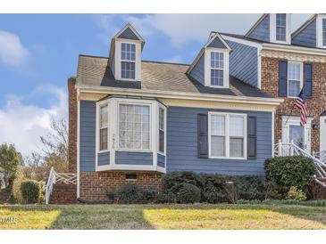 Charming blue home features dormer windows, brick accents, and a well-maintained lawn at 2820 Bedfordshire Ct, Raleigh, NC 27604