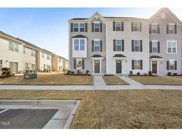 Charming two-story townhomes with manicured lawns, sidewalks, and traditional architectural details for attractive curb appeal at 4918 Neuse Commons Ln, Raleigh, NC 27616