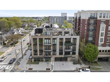 Modern condo building with brick and black accents, featuring balconies and garage doors at 615 W Peace St # 406, Raleigh, NC 27605