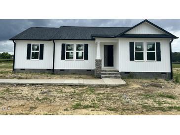 Charming home featuring a black roof, white siding, and complementing black shutters at 73 Grace Pond Ave, Benson, NC 27504