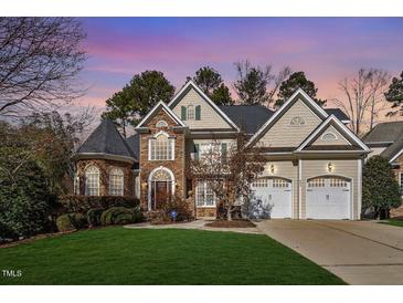 Charming two-story home featuring a stone and siding facade, well-manicured lawn, and two-car garage at 803 Landuff Ct, Cary, NC 27519