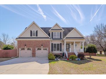 Charming two-story home with a brick and beige facade, complemented by a well-manicured lawn at 100 Watkins Farm Rd, Rolesville, NC 27571