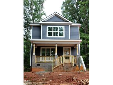 Charming two-story home featuring a welcoming front porch, neutral exterior paint, and beautiful new windows at 105 Sherwood Ln, Hillsborough, NC 27278
