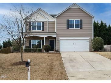 Charming two-story home with a well-manicured lawn and attached two-car garage at 1113 Crendall Way, Wake Forest, NC 27587