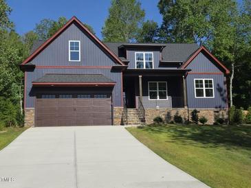 Charming craftsman style home featuring a two-car garage and inviting front porch at 140 Pilot Ridge Rd, Zebulon, NC 27597