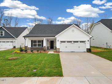 Charming single Gathering home with a manicured lawn, attached garage, and beautiful curb appeal at 1985 Meadowview Dr, Graham, NC 27253