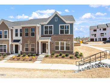 New two-story brick townhome with a landscaped yard and a modern design at 203 Frosted Iris Lane St # 181, Garner, NC 27529