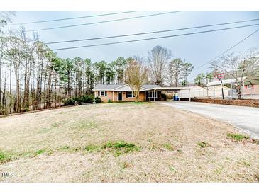Ranch-style home featuring a large front yard and covered carport at 2104 Live Oak Dr, Sanford, NC 27330