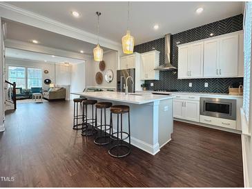Bright kitchen features a large center island with seating and sleek stainless steel appliances at 322 Clementine Dr, Cary, NC 27519