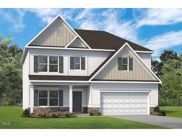 New two-story home featuring attached garage and stone accents, with a manicured lawn and a welcoming entryway at 508 Olivia Crossing Ct # 17, Four Oaks, NC 27524