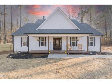 Charming one-story home featuring a welcoming front porch and a well-maintained yard at 5171 S River Rd, Lillington, NC 27546