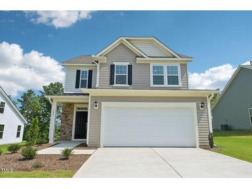 Charming two-story home featuring a two-car garage and stone accents at 542 Winding Crk Dr, Lillington, NC 27546