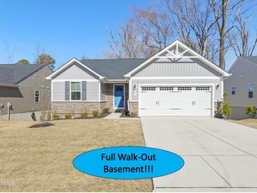 Charming single-story home boasts a two-car garage and a welcoming blue front door at 612 Jasmine St, Wendell, NC 27591