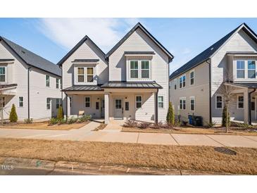 Charming two-story townhome with modern architecture, covered entrance, and beautifully landscaped front yard at 857 Athens Dr # 102, Raleigh, NC 27606