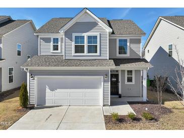 Charming two-story home with gray siding, a two-car garage, and manicured landscaping at 88 Antler Steel Dr, Clayton, NC 27527