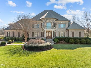 Impressive brick home with stone accents, manicured lawn, and mature landscaping offers stately curb appeal at 1017 Payton Ct, Raleigh, NC 27614