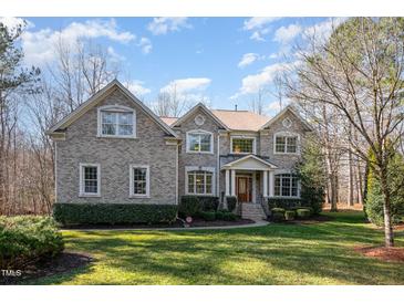 Charming two-story brick home with manicured lawn and mature landscaping at 4009 Brittabby Ct, Raleigh, NC 27606
