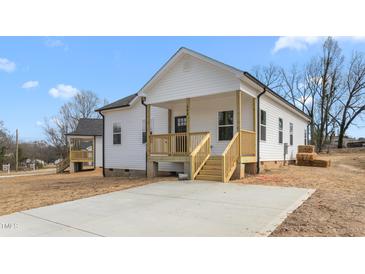 Charming home exterior with freshly painted siding and a quaint, inviting front porch and new landscaping at 603 Lee St, Burlington, NC 27217