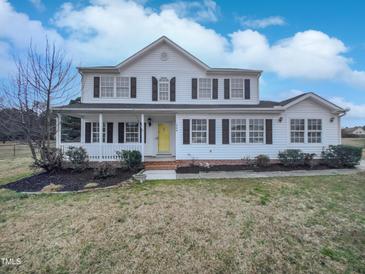 Charming two-story home with a welcoming front porch and a bright yellow front door at 1009 Bittbourg Ln, Wendell, NC 27591