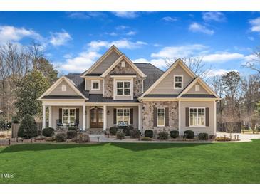 Charming two-story home with a manicured lawn, stone accents, and inviting front porch at 1100 Kingwood Dr, Raleigh, NC 27609