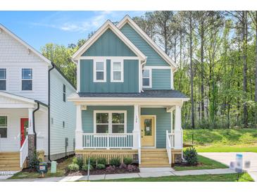 Charming two-story home featuring blue siding, a welcoming front porch, and manicured landscaping at 120 Weavers Grove Dr, Chapel Hill, NC 27514