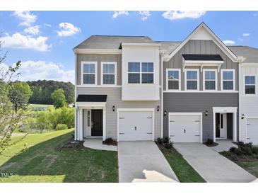 Charming townhouse featuring a gray exterior, a two-car garage, well-maintained landscaping and ample windows at 156 Fideaux Blvd # 248, Raleigh, NC 27603