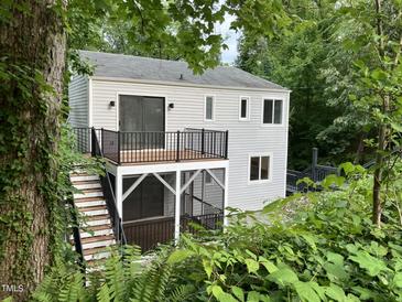 Charming home exterior featuring a deck and screened porch, nestled among lush greenery at 3412 Rock Creek Dr, Raleigh, NC 27609