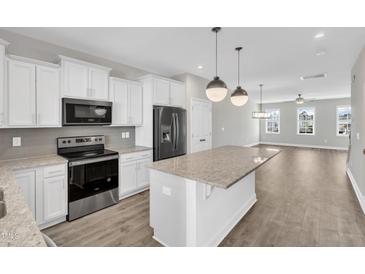 Open kitchen featuring stainless steel appliances, granite countertops, and a large island at 507 Gateway Townes Blvd, Wake Forest, NC 27587