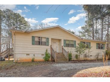 Charming single-story home featuring wood siding, green shutters, and a front porch with wooden steps at 5848 Yates Mill Pond Rd, Raleigh, NC 27606