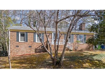 Charming brick home featuring green shutters and a welcoming front porch at 6404 Dixon Dr, Raleigh, NC 27609