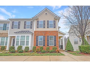 Inviting townhome features a brick facade, complemented by neat landscaping and black window shutters at 714 Cupola Dr, Raleigh, NC 27603