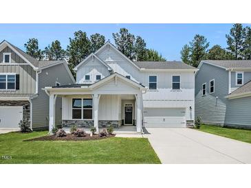 Charming two-story home with a welcoming front porch and well-manicured lawn at 7521 Percussion Dr, Apex, NC 27539